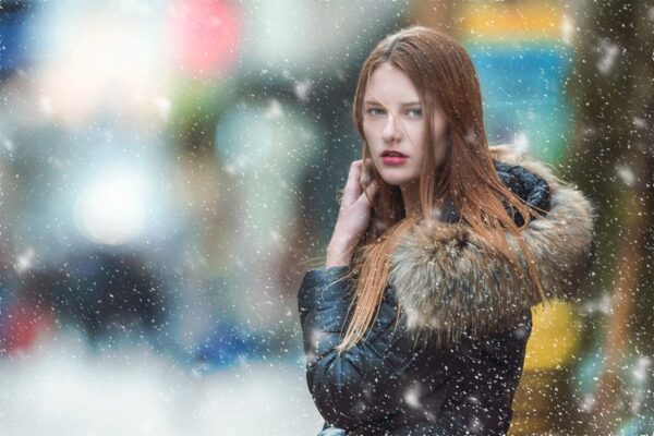 Stylish student walking in a snowy city street, showcasing smart winter layering outfits without a bulky coat.