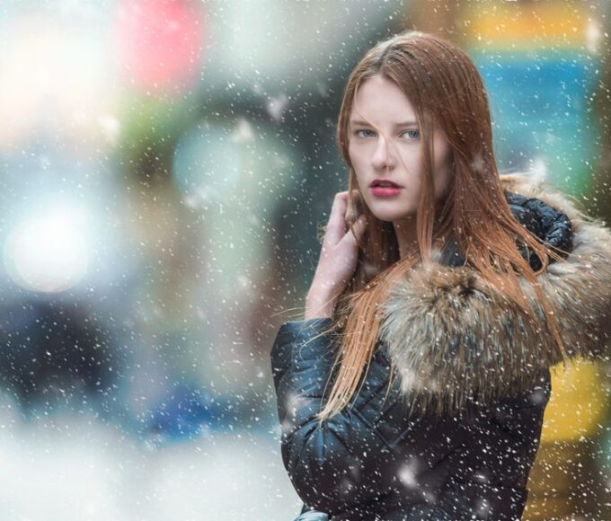 Stylish student walking in a snowy city street, showcasing smart winter layering outfits without a bulky coat.