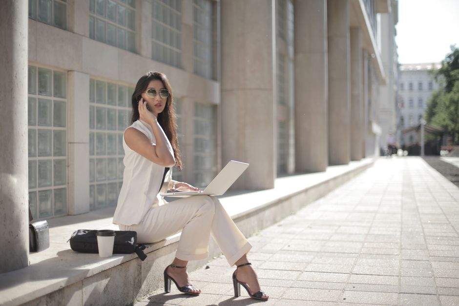 An ensemble of breathable summer work clothes laid out, featuring a linen blazer, Tencel blouse, and tailored shorts, highlighting fabrics for a summer work wardrobe in hot cities.
