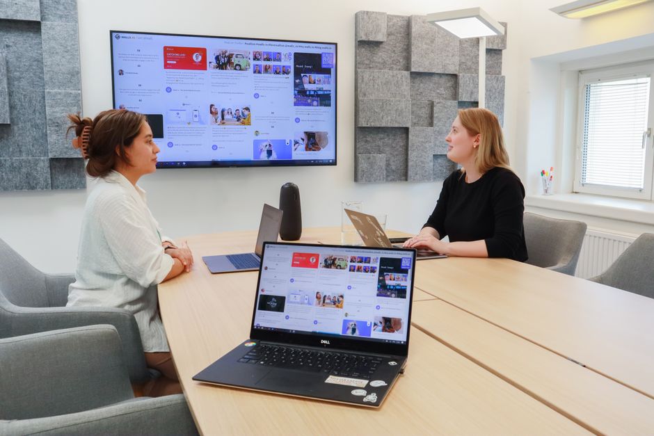 A diverse team of remote workers on a video call, reviewing AI-generated content and discussing brand consistency across different regions.