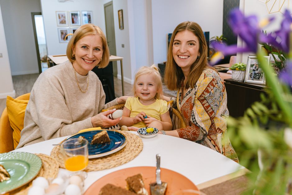 Three generations of a family, from toddler to grandparent, sharing a meal around a large table, showing the bonding aspect of shared accommodations.