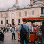A tourist firmly but politely declining a street vendor trying to sell a bracelet, emphasizing how to avoid the 'found' ring or bracelet scam.
