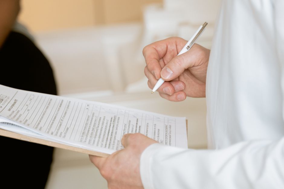 Traveler speaking with a doctor at a travel clinic, discussing necessary vaccinations and health precautions before a trip to the Americas.