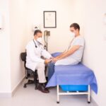 A person consulting a doctor about travel health, reviewing a map and vaccination records.
