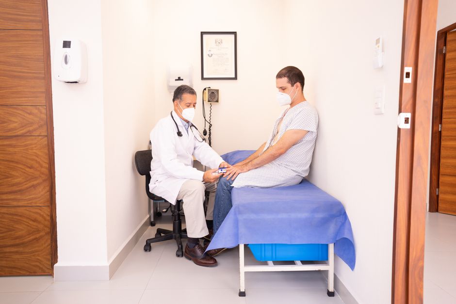 A person consulting a doctor about travel health, reviewing a map and vaccination records.