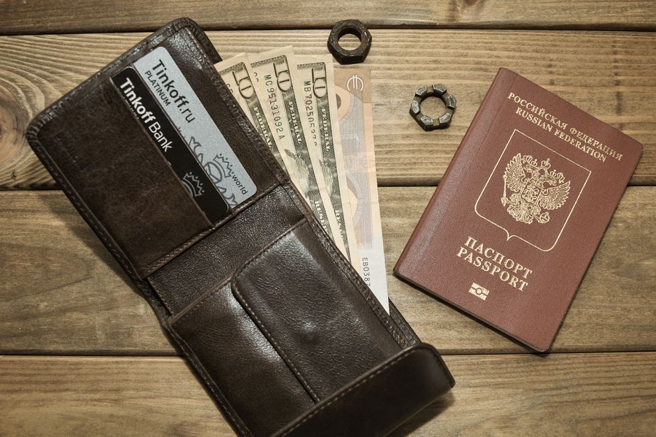 A table showing essential travel documents like a passport, a boarding pass, a Yellow Fever vaccination card, and local currency, ready for a trip.
