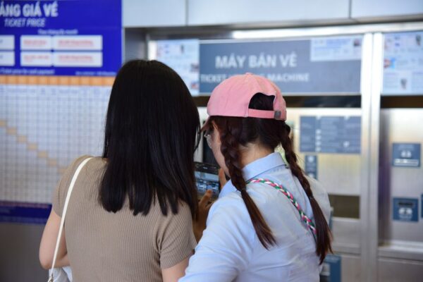 A person using a ticket machine at a metro station, purchasing a transit card for a new city.