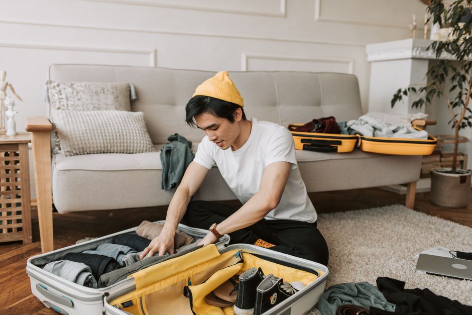 A neatly organized suitcase being packed with clothes and travel essentials laid out, showing a methodical approach to preparation.