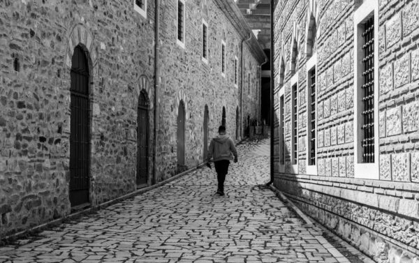 A person in comfortable sneakers walking down a sun-drenched cobblestone street in a European city, clearly enjoying their stride.