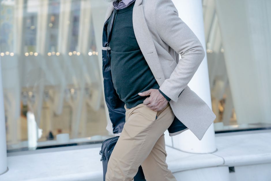 A person wearing a waterproof jacket and comfortable walking shoes, looking out over a misty cityscape, demonstrating layered travel wear.