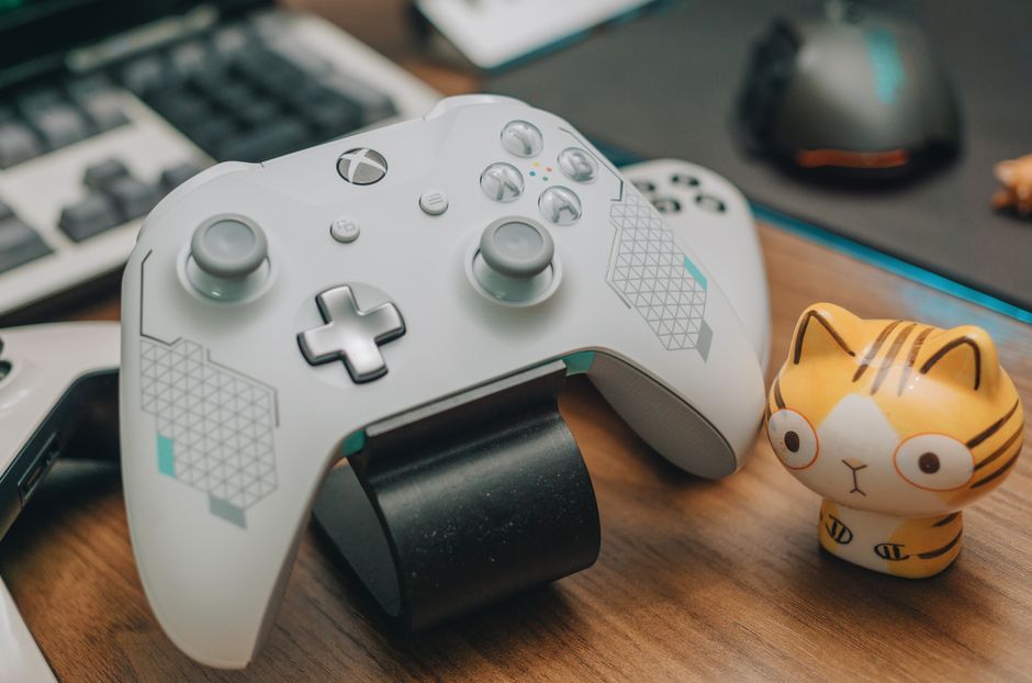 A collection of gaming controllers and a keyboard/mouse setup, symbolizing cross-platform play.