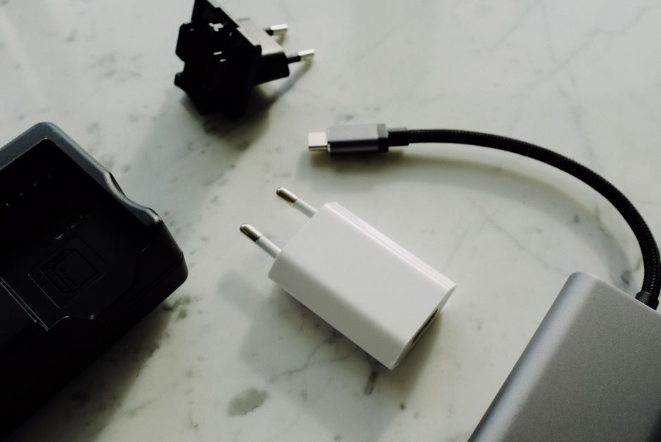 A flat lay comparison shot of several power banks of different sizes and capacities, alongside charging cables and a smartphone, demonstrating options for daily carry and travel.