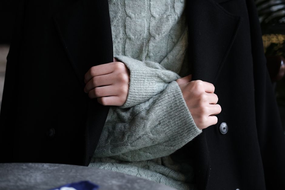 Close-up of a well-layered winter outfit, showing textured fabrics and smart accessory choices.