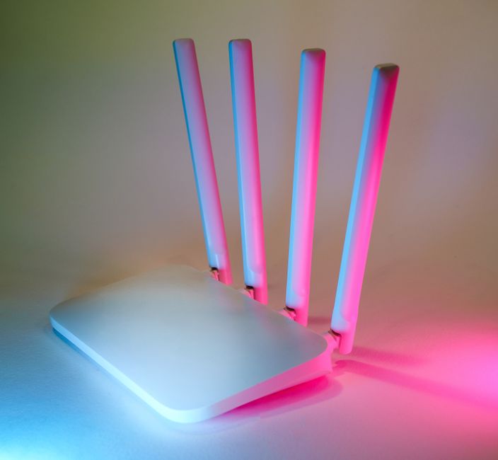 A modern Wi-Fi router placed centrally on a shelf in a clean, bright living room, showing ideal router placement.