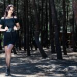 Woman in a chic simple black dress adding a stylish leather belt, demonstrating how accessories upgrade simple outfits.