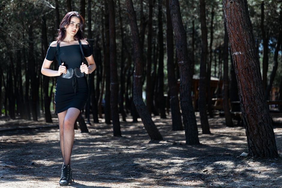 Woman in a chic simple black dress adding a stylish leather belt, demonstrating how accessories upgrade simple outfits.