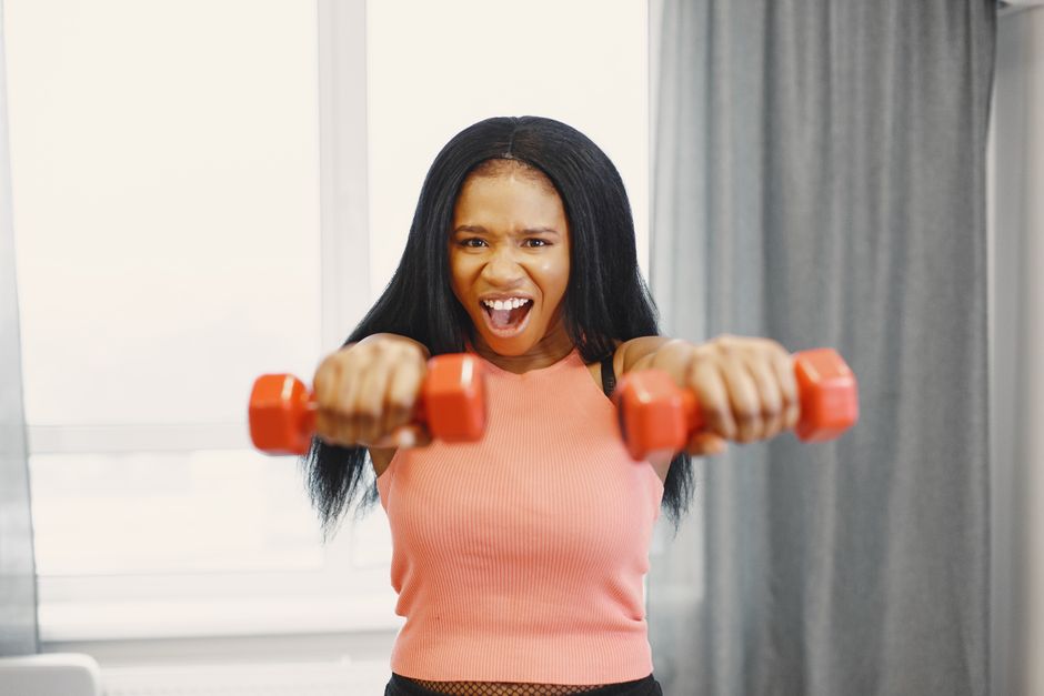 Split image showing a cozy home workout space with bands and light weights on one side, and a spacious, well-equipped commercial gym on the other, highlighting options for beginners.