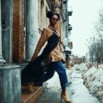 A professional woman elegantly layered in a trench coat and scarf, walking through a European city street, demonstrating versatile urban style.