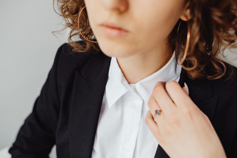 A close-up of a woman's hand wearing a sleek, silver smart ring, discreetly blending with her jewelry.