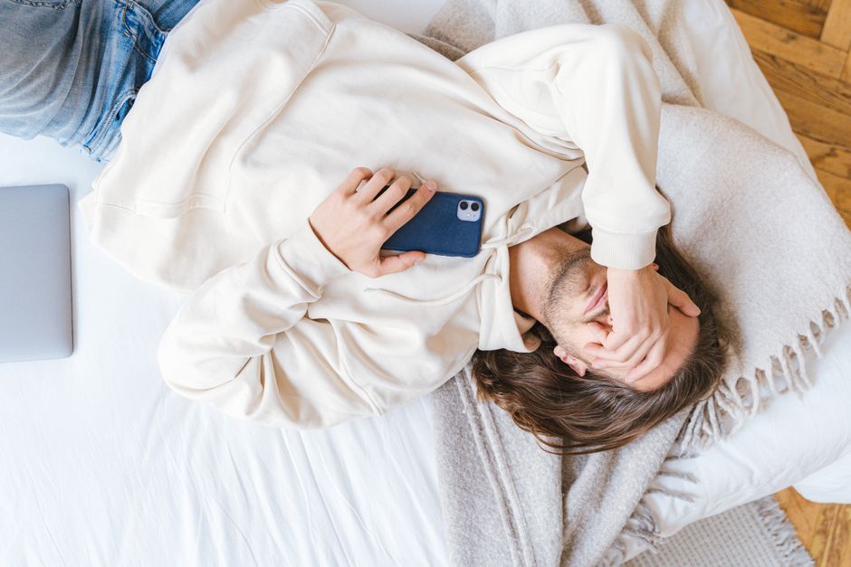 A young adult concentrating on their laptop, with their smartphone intentionally placed face down and out of reach, demonstrating focus and digital boundaries.